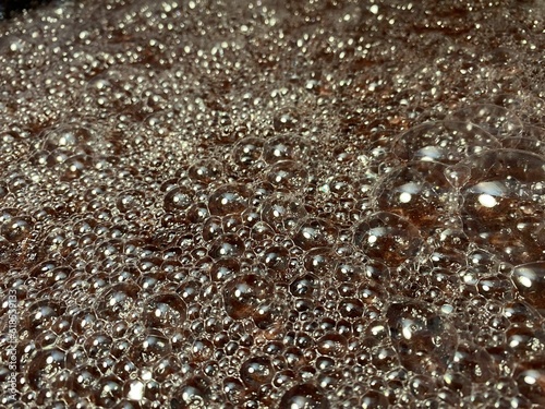 Bubbles formed on the surface of wine must caused by the residual carbon dioxide produced during the fermentation activity of yeast. Textures, close up
