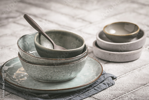 Gray stoneware plates and bowls on a rustic table, copy space photo