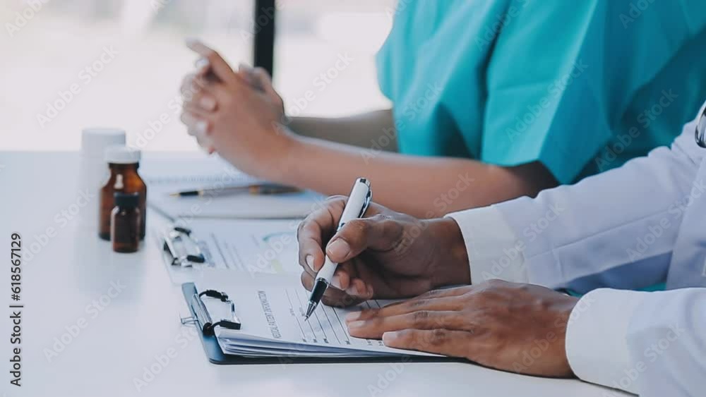 Group of healthcare workers and businessman using laptop while having a meeting in the office. Focus is on young doctor. Group of healthcare workers and businessman using laptop while having a meeting in the office. Focus is on young doctor.
