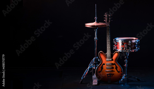 drum kit on stage on a dark background. Set of musical drums and guitars on stage.