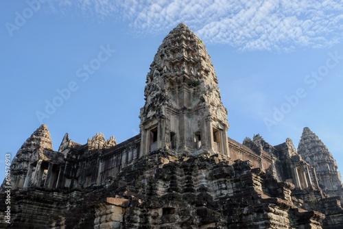 The tall decorated stone tower of the Khmer temple of Angkor Wat in Cambodia under a clear blue sky.