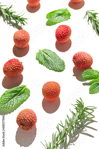 Fototapeta Naklejka Na Ścianę i Meble -  Fresh lychee fruits with rosemary and mint leaves on white background. Minimal style composition. Healthy food concept. Summer refreshment theme