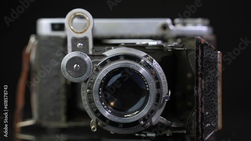 Old non-working photo camera in the open state. Dolly shot