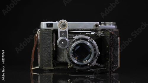 Old non-working photo camera in the open state.Turntable rotation looped
