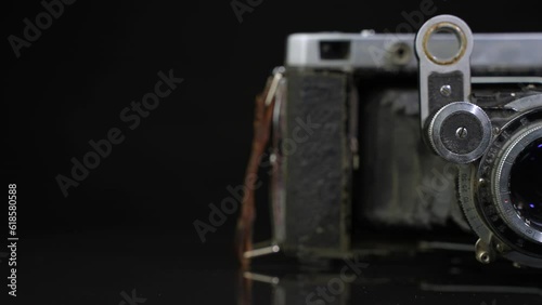 Old non-working photo camera in the open state. Dolly shot