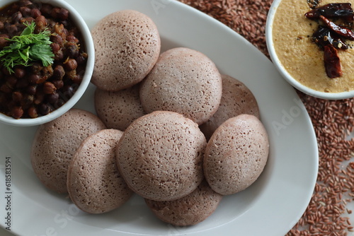 Navara rice idly served black chickpea curry. Steamed savoury rice cake made by a batter of fermented de husked black lentils and navara rice. photo