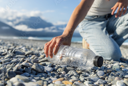 Photo Woman hand picking up plastic bottle cleaning on the beach