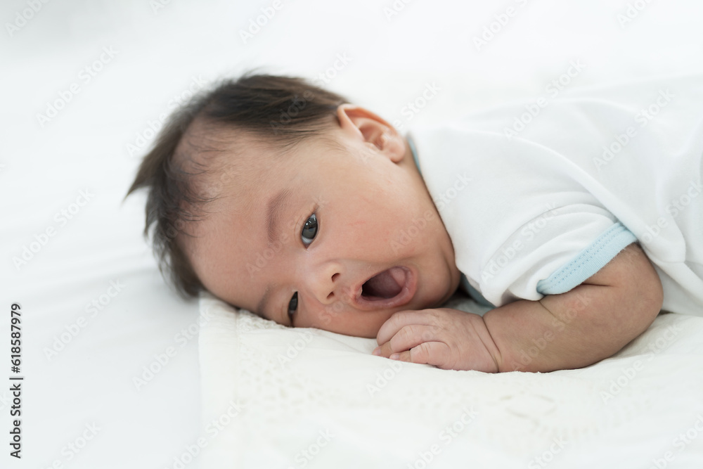Newborn baby sleeping on blanket on white bed. Infant lying on white bed. Asian newborn baby sleeping in prone position. Asian infant Newborn baby sleeping on blanket on white bed. Infant lying on white bed. Asian newborn baby sleeping in prone position. Asian infant