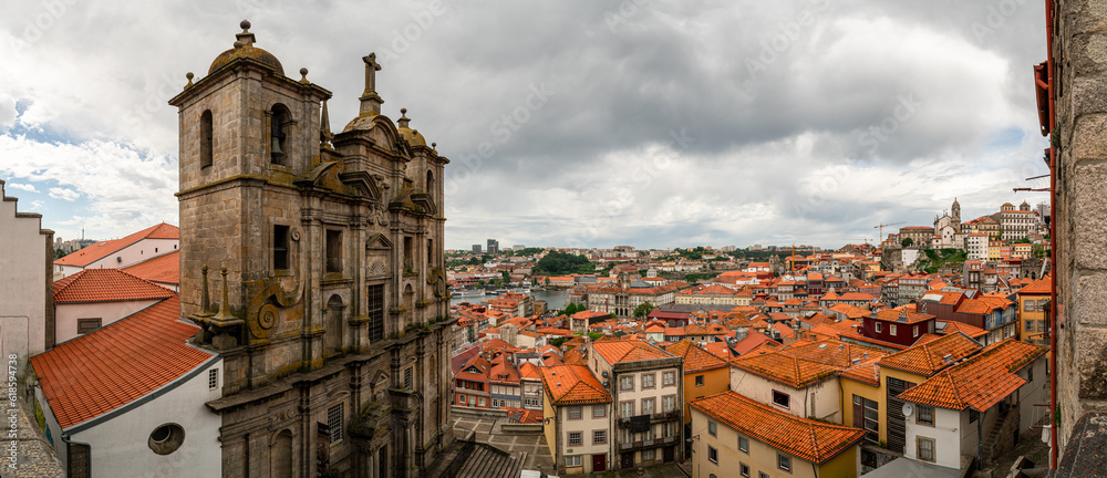 Panorama Porto town, Portugal. Wide angle view from the top, red roofs, church tower in background. Darker and moody sky.