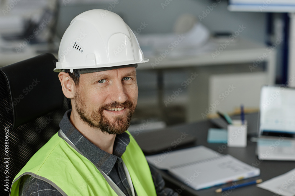 Closeup portrait of bearded man wearing hardhat at workplace in office and looking at camera, copy space Closeup portrait of bearded man wearing hardhat at workplace in office and looking at camera, copy space