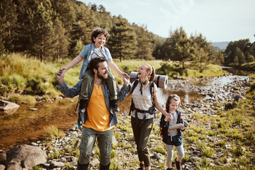 Young family hiking by a creek in the forest