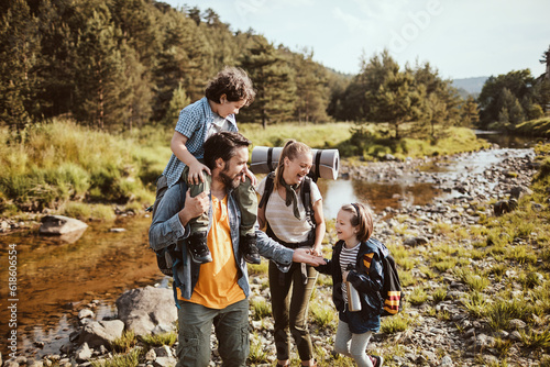 Young family hiking by a creek in the forest