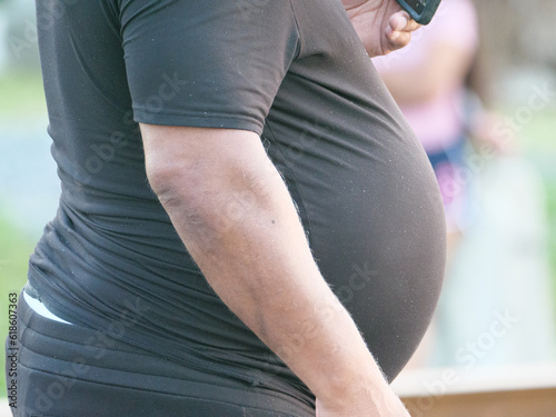 A man with a distended belly in black clothes