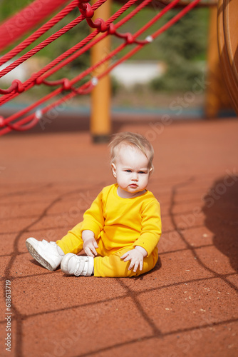 Cheerful baby toddler plays on the playground in the summer © KseniaJoyg