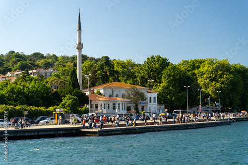 Touristic sightseeing ships in Golden Horn bay of Istanbul and mosque with Sultanahmet district against blue sky and clouds. Istanbul, Turkey during sunny summer day photo