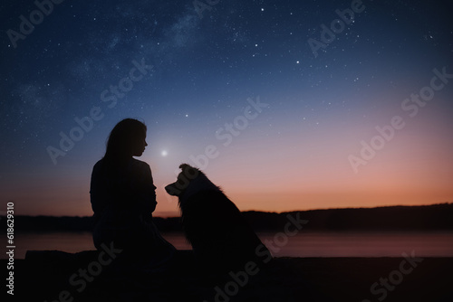Black silhouettes of a girl and Border collie dog on the star night background