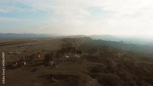 Aerial view Vashlovani national park rangers station with picnic area for tourist rest and bbq. Deserted georgian Tusheti landscape panorama on sunset photo