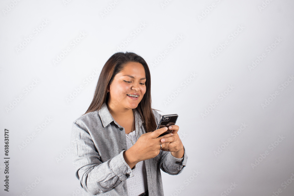 photograph of latina woman using cell phone on a photo studio background. Concept of people and technology. photograph of latina woman using cell phone on a photo studio background. Concept of people and technology.