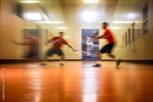 An action-packed scene of a racquetball game, the players moving so fast they're just a blur against the backdrop of the vivid court