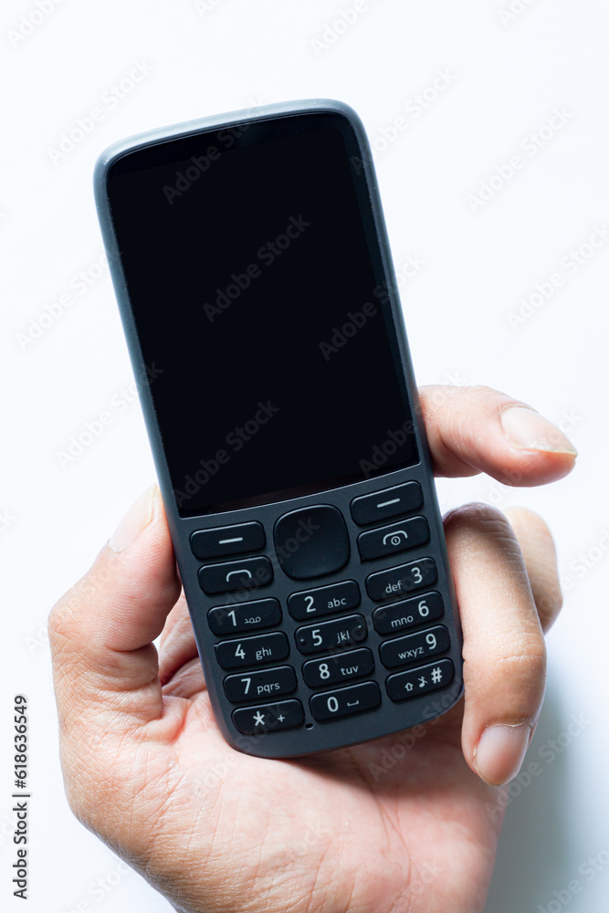 Pressing the button of an old mobile phone on a white background,old mobile phone isolated white background Pressing the button of an old mobile phone on a white background,old mobile phone isolated white background