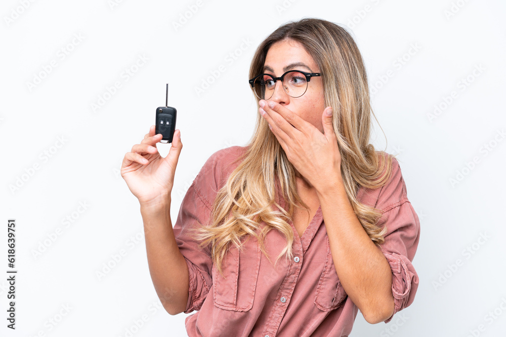 Young pretty Uruguayan woman holding car keys isolated on white background with surprise and shocked facial expression Young pretty Uruguayan woman holding car keys isolated on white background with surprise and shocked facial expression