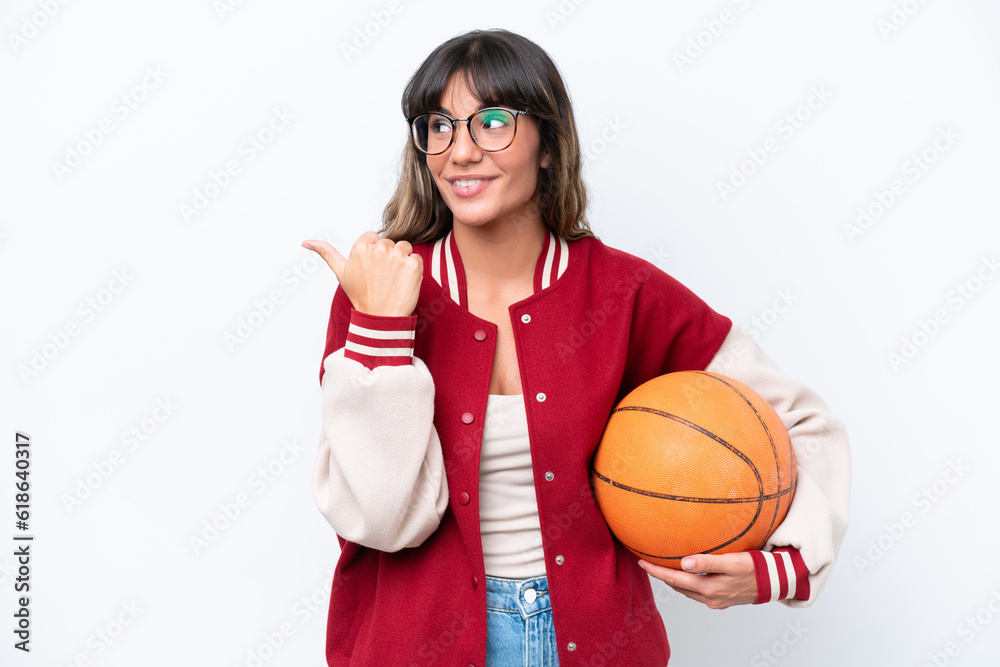 Young caucasian woman playing basketball isolated on white background pointing to the side to present a product Young caucasian woman playing basketball isolated on white background pointing to the side to present a product