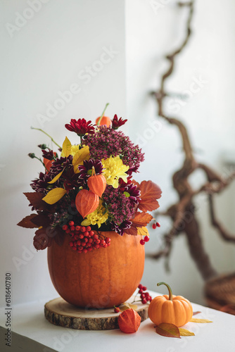 Obraz na plátně Autumn bouquet of bright flowers in a pumpkin handmade vase