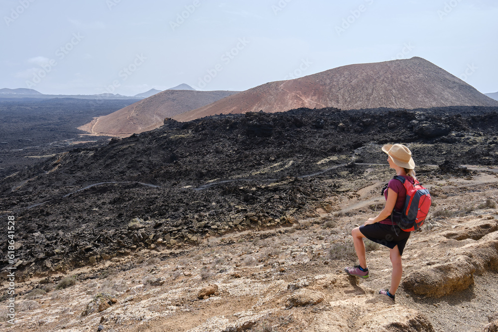 Woman hiker admiring the volcanic landscape in Lanzarote, Canary Islands