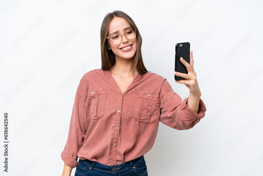Naklejka premium Young pretty caucasian woman isolated on white background making a selfie