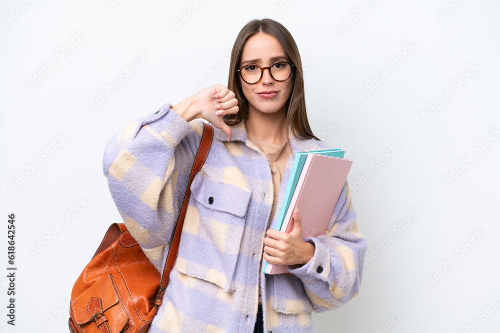 Young beautiful student woman isolated on white background showing thumb down with negative expression