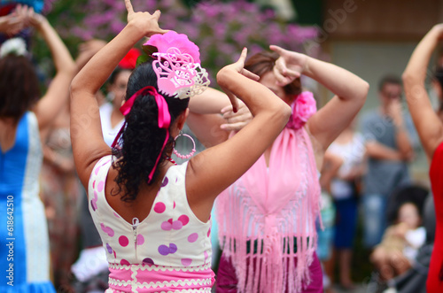 Women dancing in the street dressed in flamenco style clothing at the Spanish Romeria festival