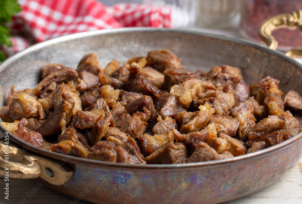 Muslims Traditional Sacrifice holiday food lamb, Turkish roasted meat in copper pot on table top. Turkish Kavurma. (Turkish name; Kurban kavurma) Muslims Traditional Sacrifice holiday food lamb, Turkish roasted meat in copper pot on table top. Turkish Kavurma. (Turkish name; Kurban kavurma)