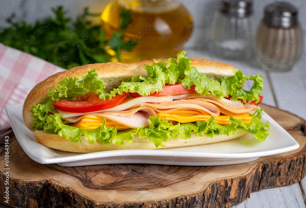 Cheese, ham, lettuce and tomato slices in an appetizing tasty sandwich. Cheese, ham, lettuce and tomato slices in an appetizing tasty sandwich.