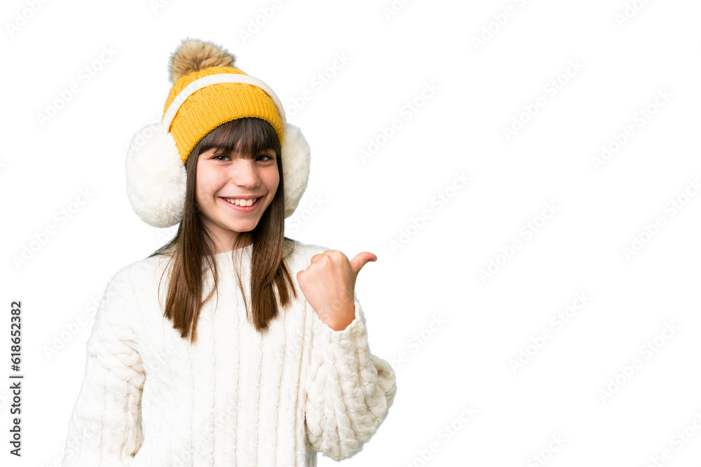 Little caucasian girl wearing winter muffs over isolated background pointing to the side to present a product Little caucasian girl wearing winter muffs over isolated background pointing to the side to present a product