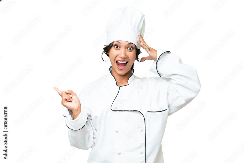Young chef Argentinian woman over isolated background surprised and pointing finger to the side Young chef Argentinian woman over isolated background surprised and pointing finger to the side