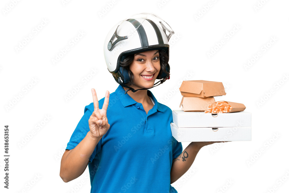 Young Argentinian deliver fast food over isolated background smiling and showing victory sign Young Argentinian deliver fast food over isolated background smiling and showing victory sign