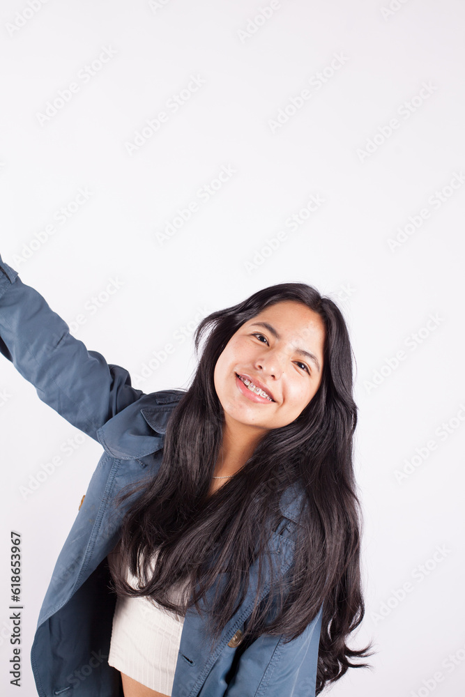 Portrait of latina woman grimacing on light background in photo studio. Concept of people. Portrait of latina woman grimacing on light background in photo studio. Concept of people.