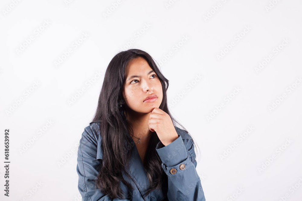 Photograph of young woman with thoughtful gesture on white studio background. Concept of people and hobbies. Photograph of young woman with thoughtful gesture on white studio background. Concept of people and hobbies.