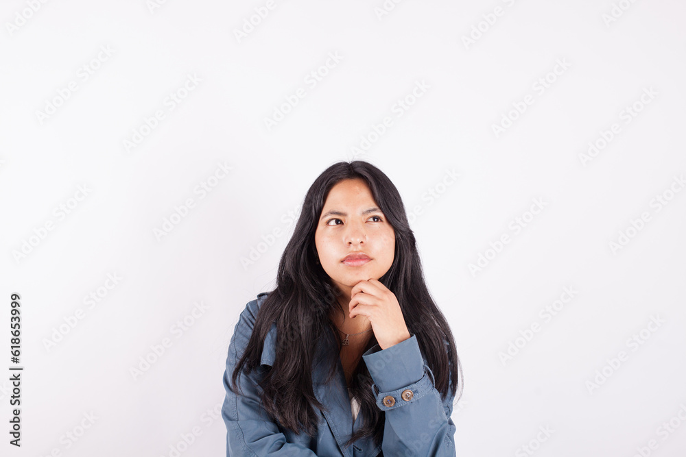 Photograph of young woman with thoughtful gesture on white studio background. Concept of people and hobbies. Photograph of young woman with thoughtful gesture on white studio background. Concept of people and hobbies.