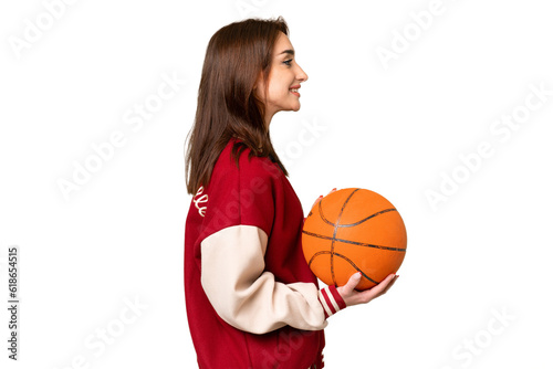 Young basketball player woman over isolated chroma key background laughing in lateral position