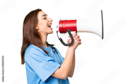 Young nurse woman over isolated chroma key background shouting through a megaphone