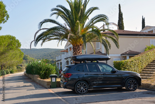 A luxury SUV is parked outside a villa or hotel. Car road trip with comfort © Serhii