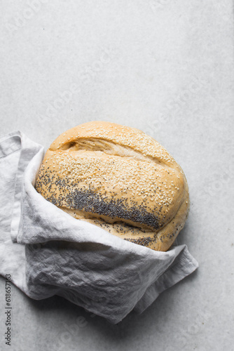 Top view of round homemade bread on a linen napkin, Potbrood coated with sesame seeds photo