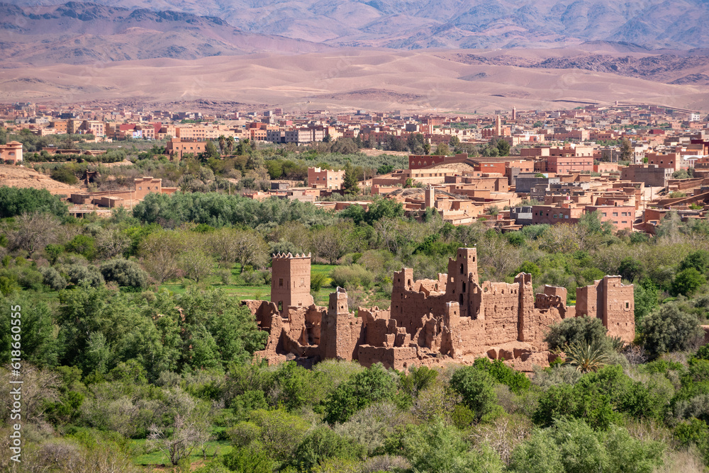 Old deserted big Kasbah on a hill surrounded by a palm grove in the valley of roses