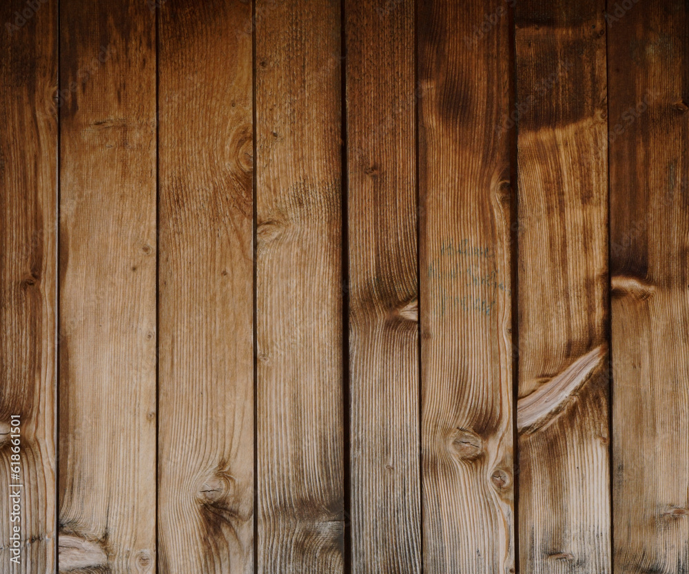 Dark stained reclaimed wood surface with aged boards lined up. Wooden