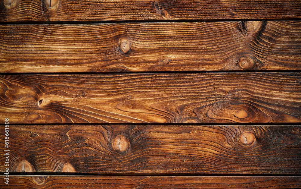 Dark stained reclaimed wood surface with aged boards lined up. Wooden