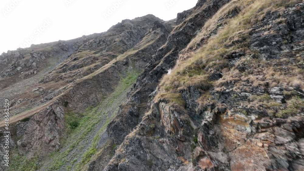 Aerial shot of Rocky Mountain Goats Climbing a steep mountaintop cliff in Svaneti mountains. Georgia Aerial shot of Rocky Mountain Goats Climbing a steep mountaintop cliff in Svaneti mountains. Georgia