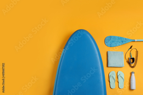 Flat lay composition with SUP board on yellow background, space for text. Water sport