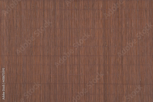 Texture of dark brown bamboo mat.Bamboo fine tablecloth background. © zhikun sun