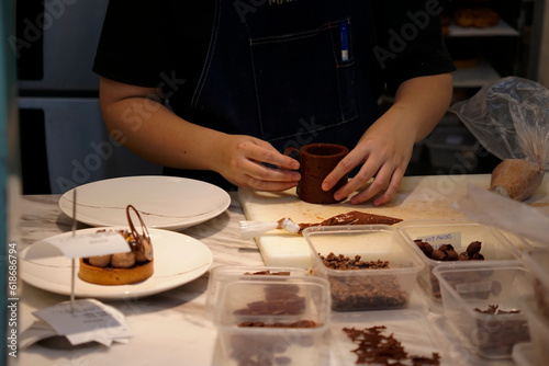 Pastry chef assembling a chocolate cake in the kitchen                               
